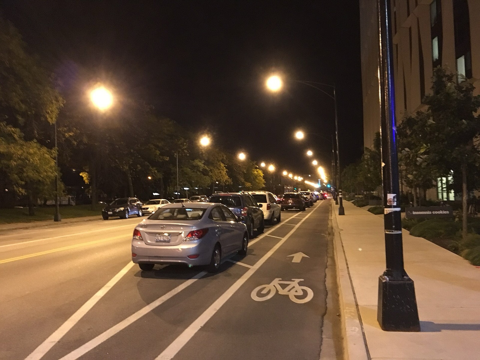 A parking-protected bike lane on 55th Street in Chicago at night